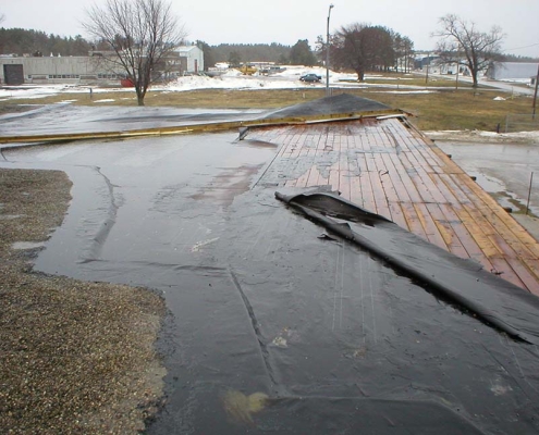 water pooling and wind damaged roof sproule